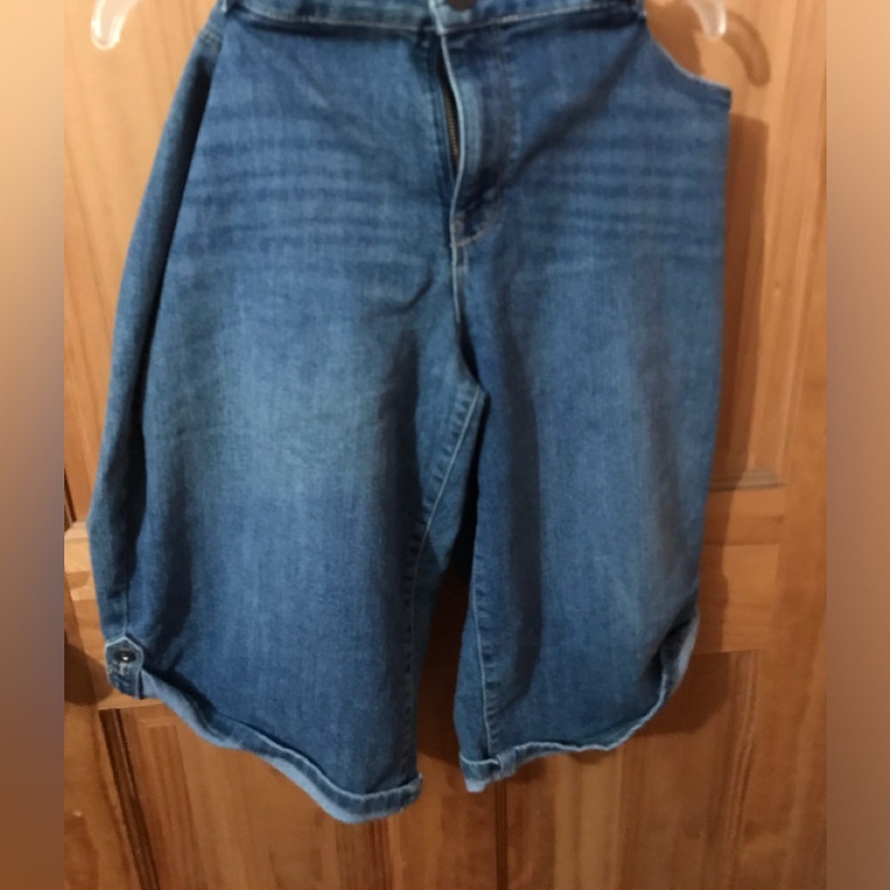 Gently worn denim Bermuda shorts cuffed at the bottoms,